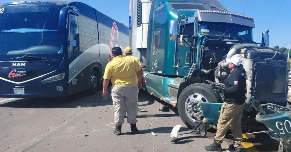 Accidente de autobús y camión en carretera con dos personas inspeccionando el daño.