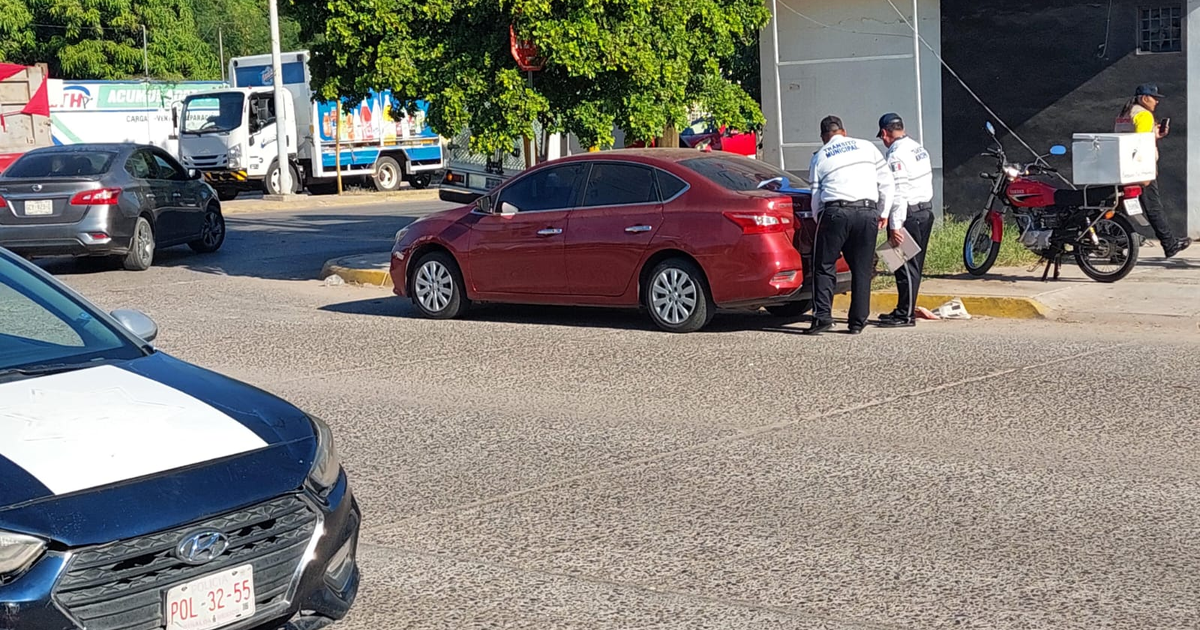 Oficiales revisan un automóvil rojo tras accidente en Los Mochis