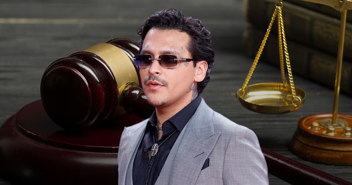 Hombre con gafas oscuras en entorno jurídico, mazo de juez y balanza de justicia, relacionado con audiencia de Christian Nodal.