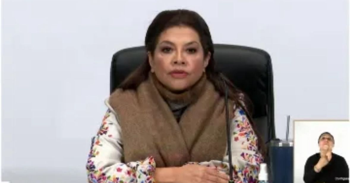 Mujer en conferencia con abrigo floral y lenguaje de señas, relacionada con la marcha 'Generación Z'.