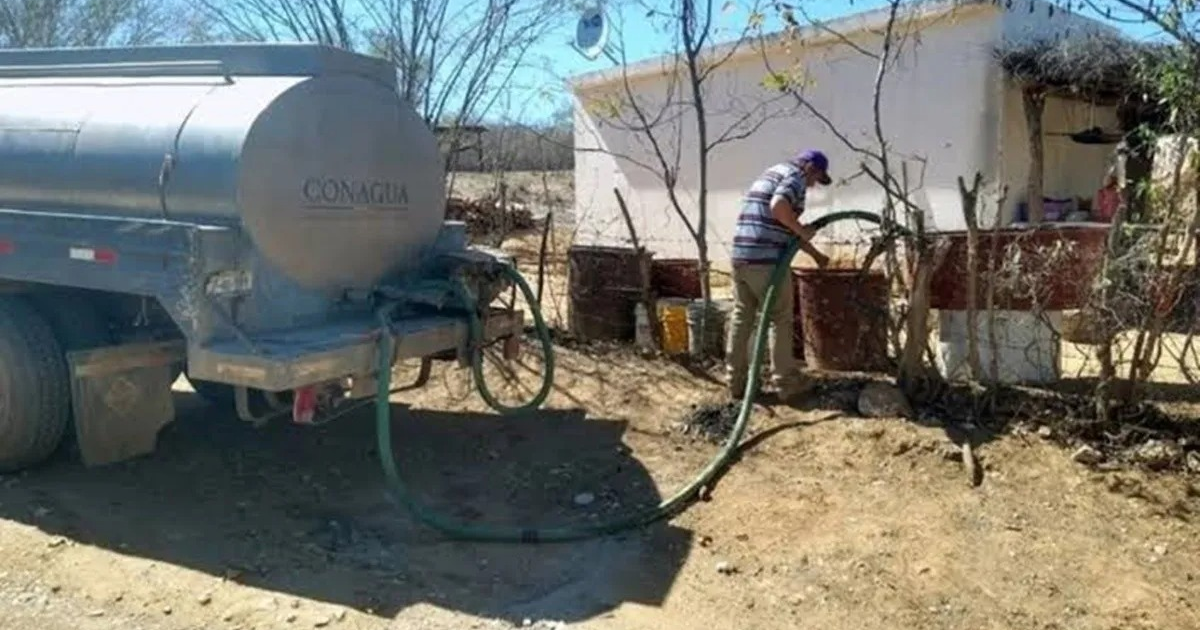 Camión cisterna suministrando agua en El Fuerte, Sinaloa, en medio de un entorno desértico.