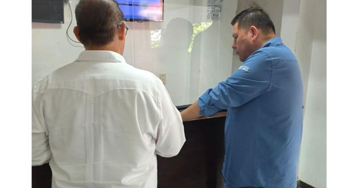 Dos personas de espaldas en un entorno institucional, una con camisa blanca y otra con camisa azul, posiblemente en la Vicefiscalía Regional Zona Norte.