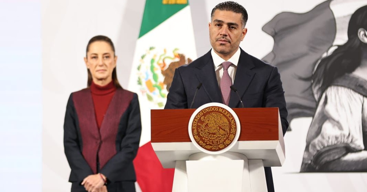 Hombre dando discurso en Culiacán con bandera de México al fondo