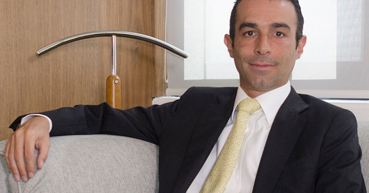 Hombre en traje formal sentado en un sofá gris, vinculado al caso de Antonio "N", alias El Goofy.