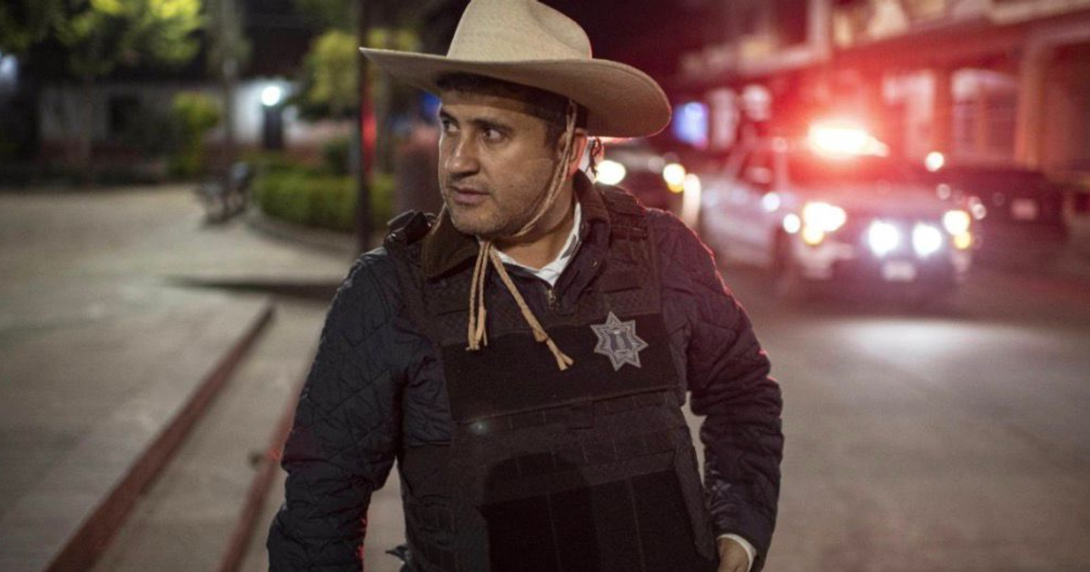 Hombre con sombrero y chaleco antibalas en operativo nocturno en Morelia