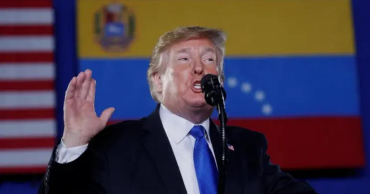 Orador frente a banderas de Estados Unidos y Venezuela discutiendo operaciones antinarcóticos.