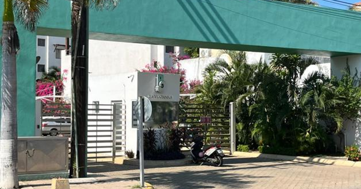 Entrada al complejo residencial 'La Ventana' en Mazatlán con marco verde y scooter estacionado.