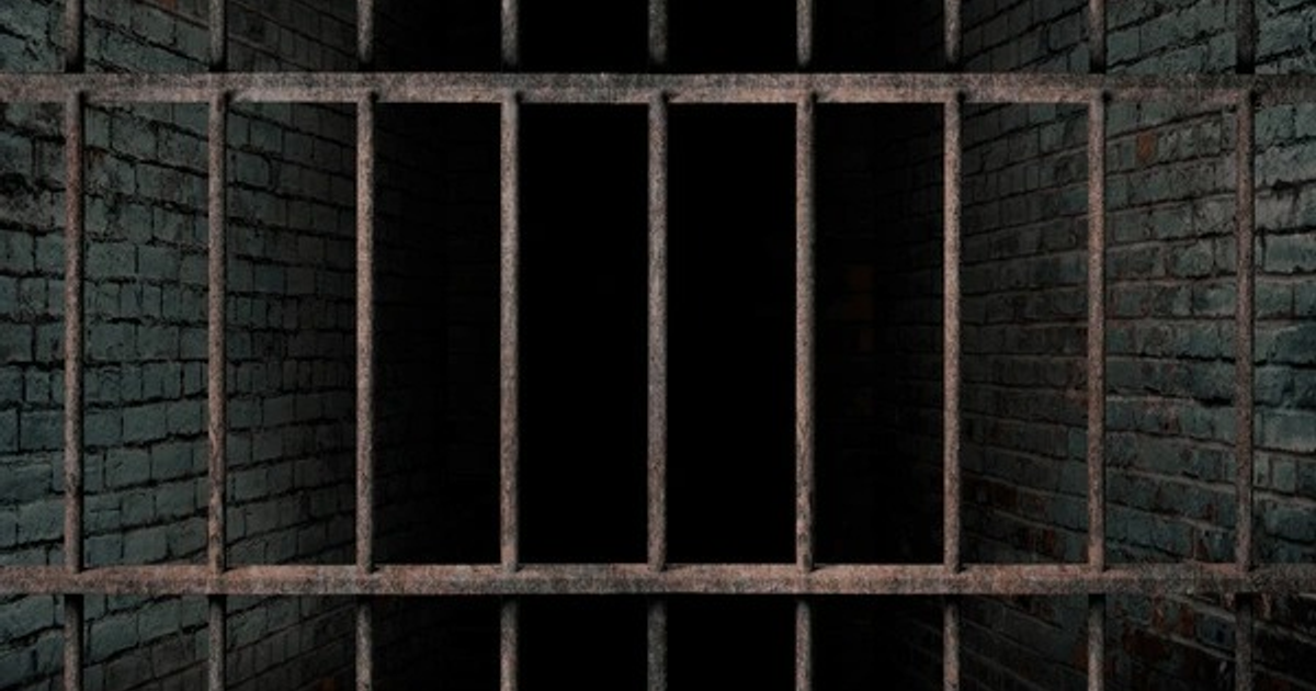 Rejas de metal en un entorno oscuro, simbolizando extorsiones desde prisiones.