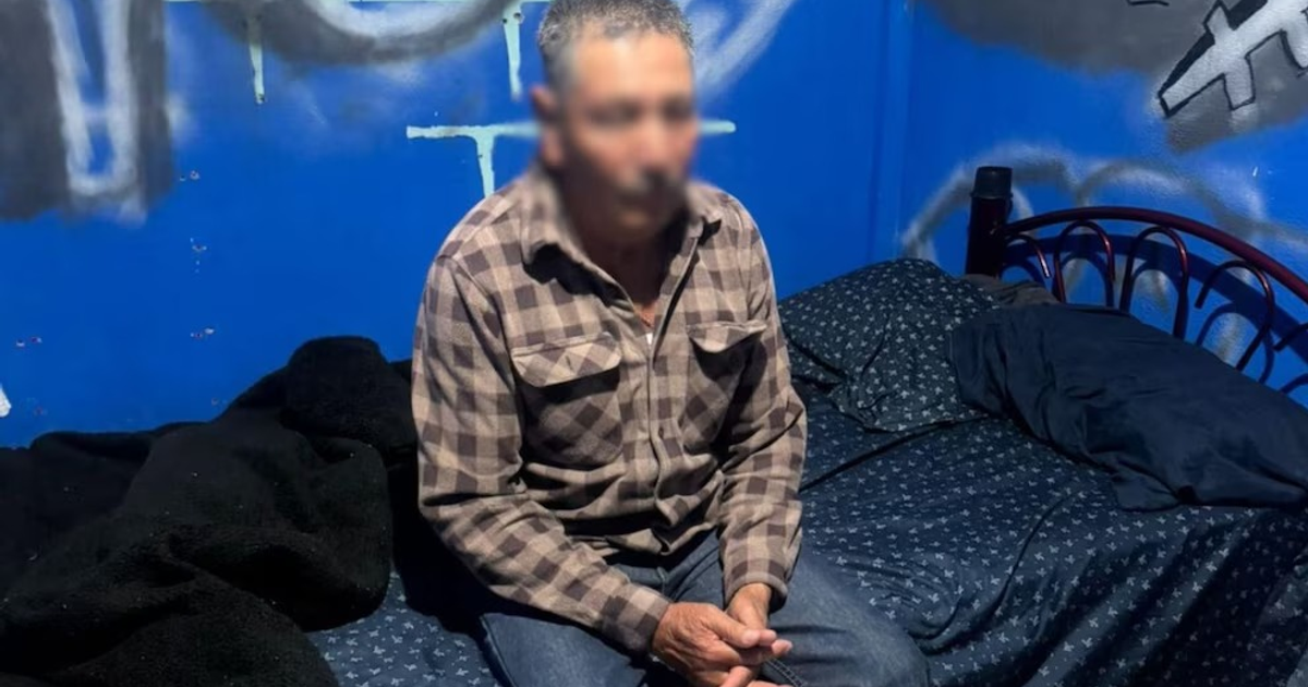 Persona sentada en una cama en una habitación azul, relacionada con el caso de Fernando Galindo Salvador.