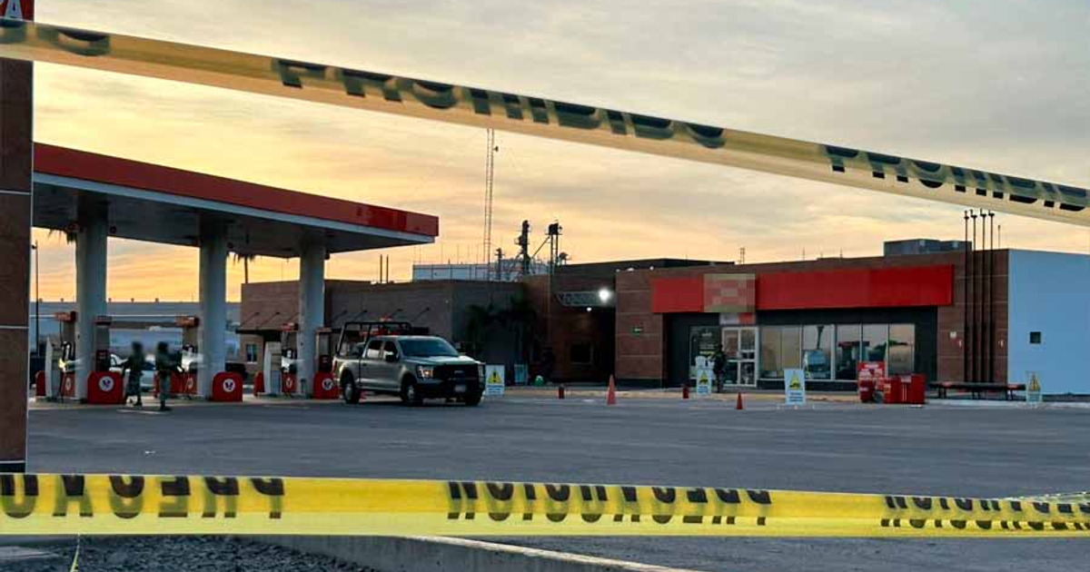Gasolinera clausurada en Los Mochis con cinta de advertencia amarilla y vehículo gris cercano.