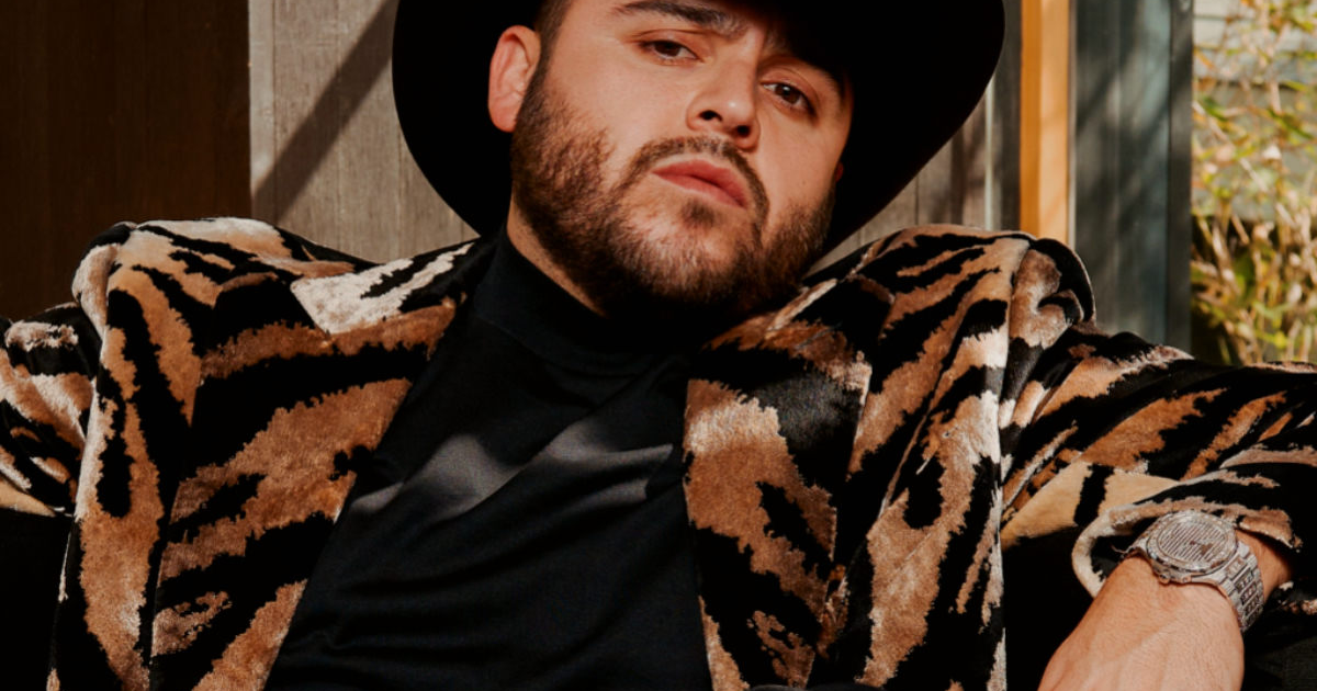 Persona con abrigo de tigre y sombrero en un entorno interior, relacionada con el caso judicial de Gerardo Ortiz.