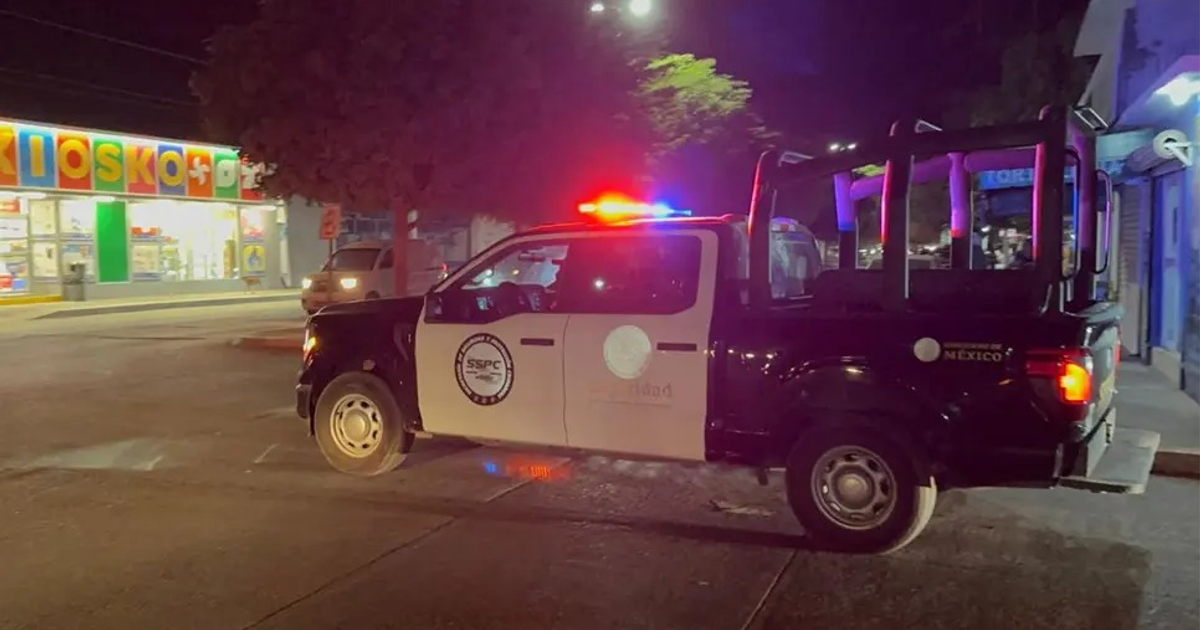 Camioneta de policía con luces rojas y azules en una calle urbana nocturna en Guasave, parte de los operativos federales.