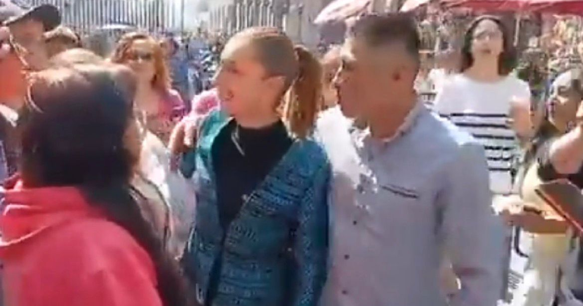 Grupo de personas conversando al aire libre en Ciudad de México, con una mujer de suéter colorido en el centro.