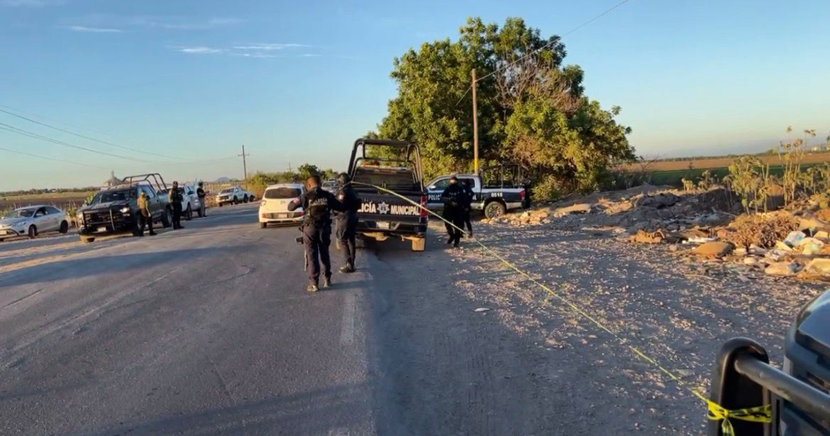 Patrullas y agentes de seguridad en carretera rural con cinta amarilla, operativo tras hallazgo de cuerpo en Navolato.