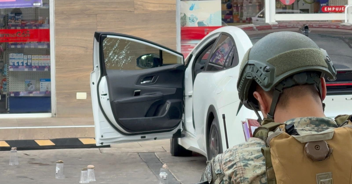 Toyota Prius blanco con puerta abierta y soldado en escena de crimen en Culiacán