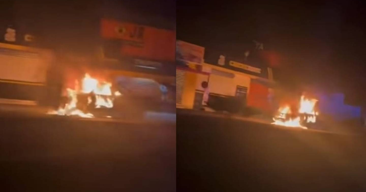 Patrulla en llamas en Mazatlán durante la noche, con luces de fondo indicando actividad.