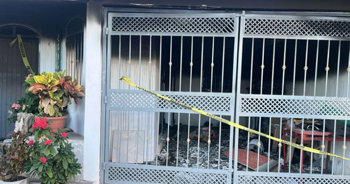 Entrada de casa incendiada en Culiacán con reja dañada y cinta policial