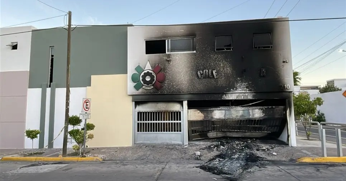 Fachada de colegio en Culiacán dañada por incendio con hollín y restos en el suelo.