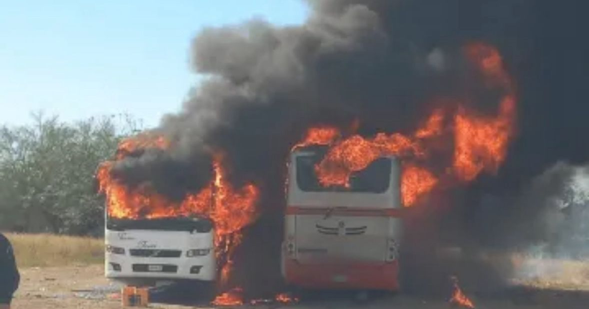 Dos autobuses en llamas en Guasave, Sinaloa, con humo negro en el aire.