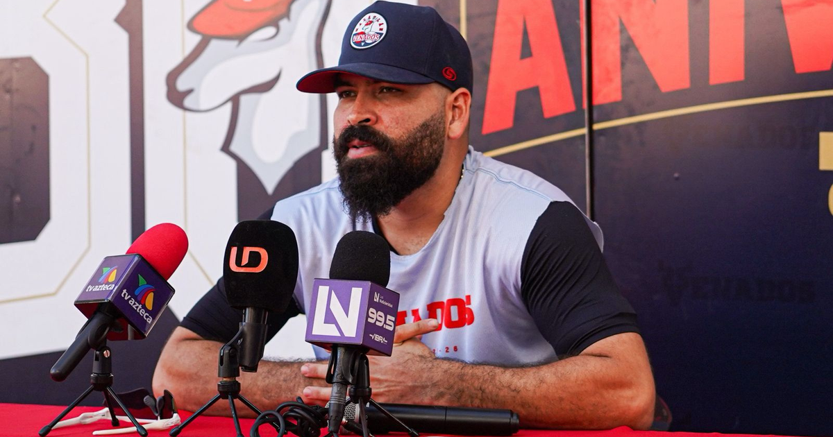 José Luis Urquidy en conferencia de prensa, rodeado de micrófonos, tras ser nombrado Pitcher de la Semana.