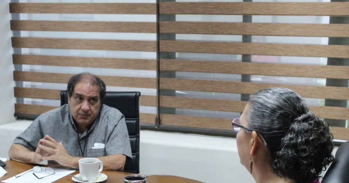 Dos personas en una reunión discutiendo un caso de desaparición en Culiacán.