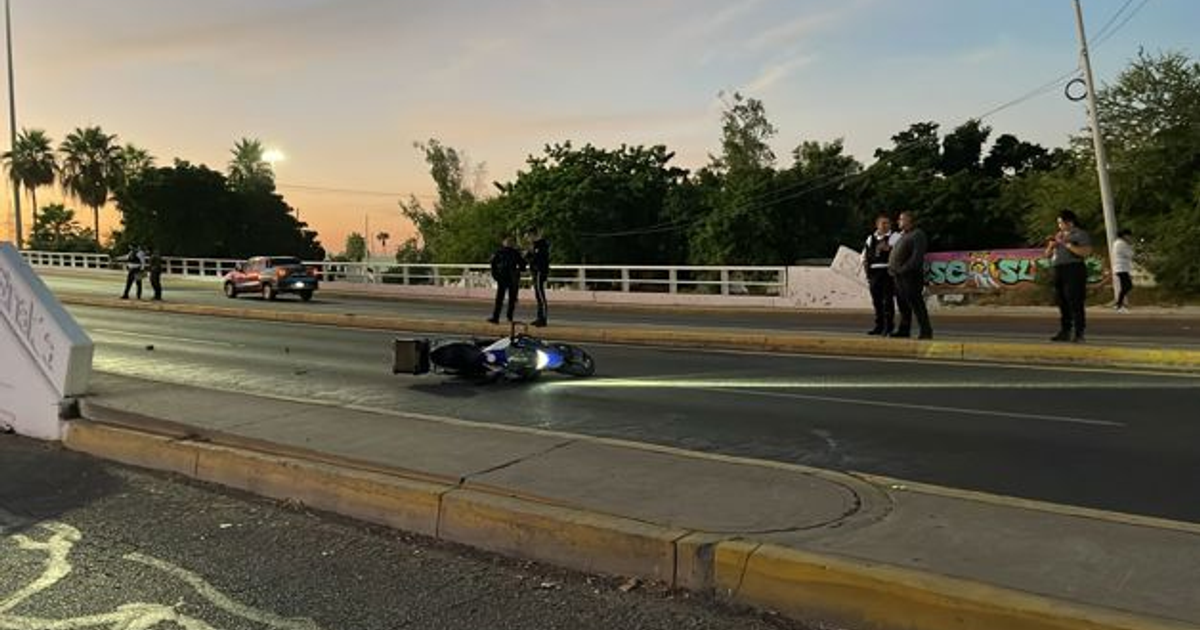 Escena de accidente de motocicleta en Culiacán con motocicleta caida, policías y testigos observando