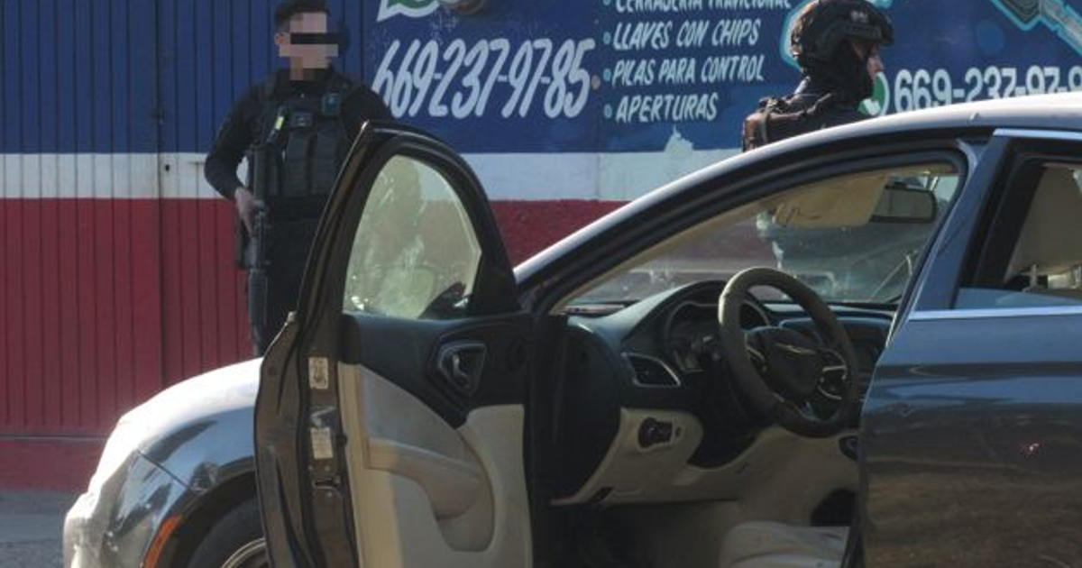 Vehículo con puerta abierta y personal de seguridad en intervención tras ataque en Mazatlán