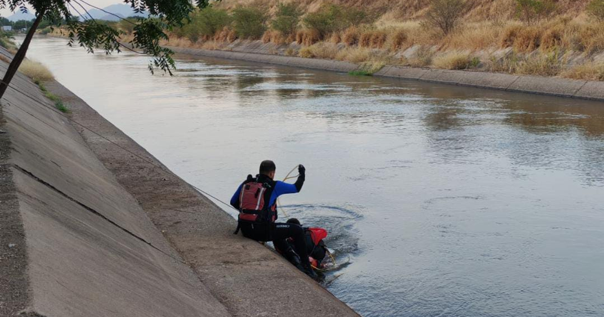 Un rescatista con cuerda operando en el canal Humaya, Culiacán