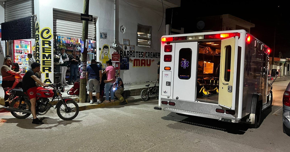 Ambulancia y personas reunidas en una calle de Mazatlán durante una emergencia nocturna.