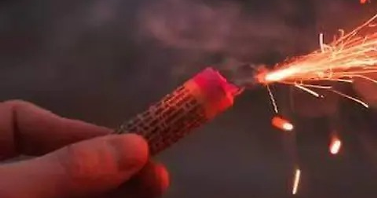 Una mano sosteniendo un chispómetro en Culiacán, Sinaloa, encendido y emitiendo chispas y humo.