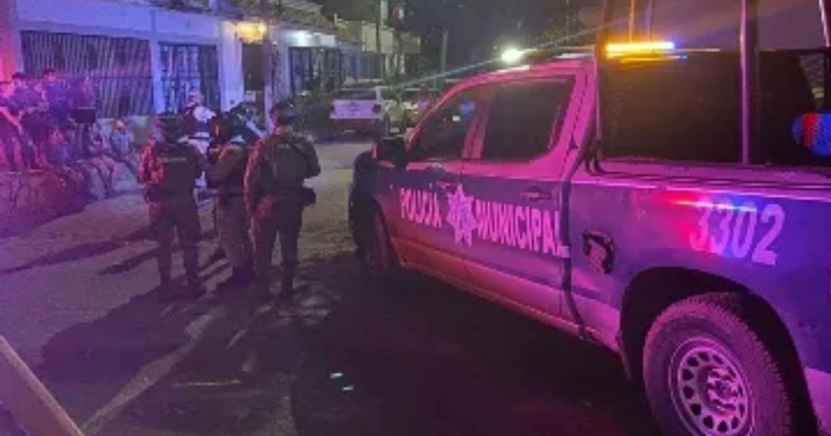 Camioneta de policía municipal con luces encendidas y oficiales en una intervención nocturna en Mazatlán.