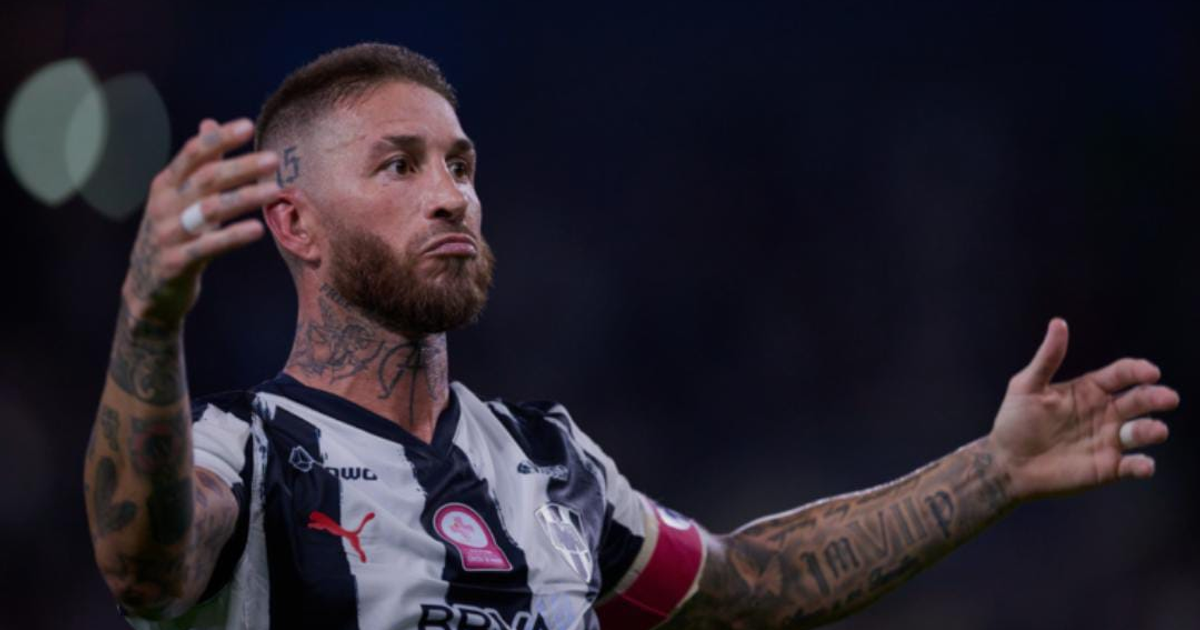 Sergio Ramos con Rayados luciendo preocupado en el campo con tatuajes visibles.