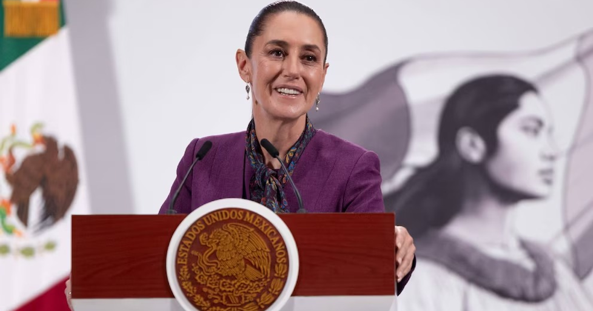 Claudia Sheinbaum en discurso sobre los siete años de transformación en México, con bandera de fondo.