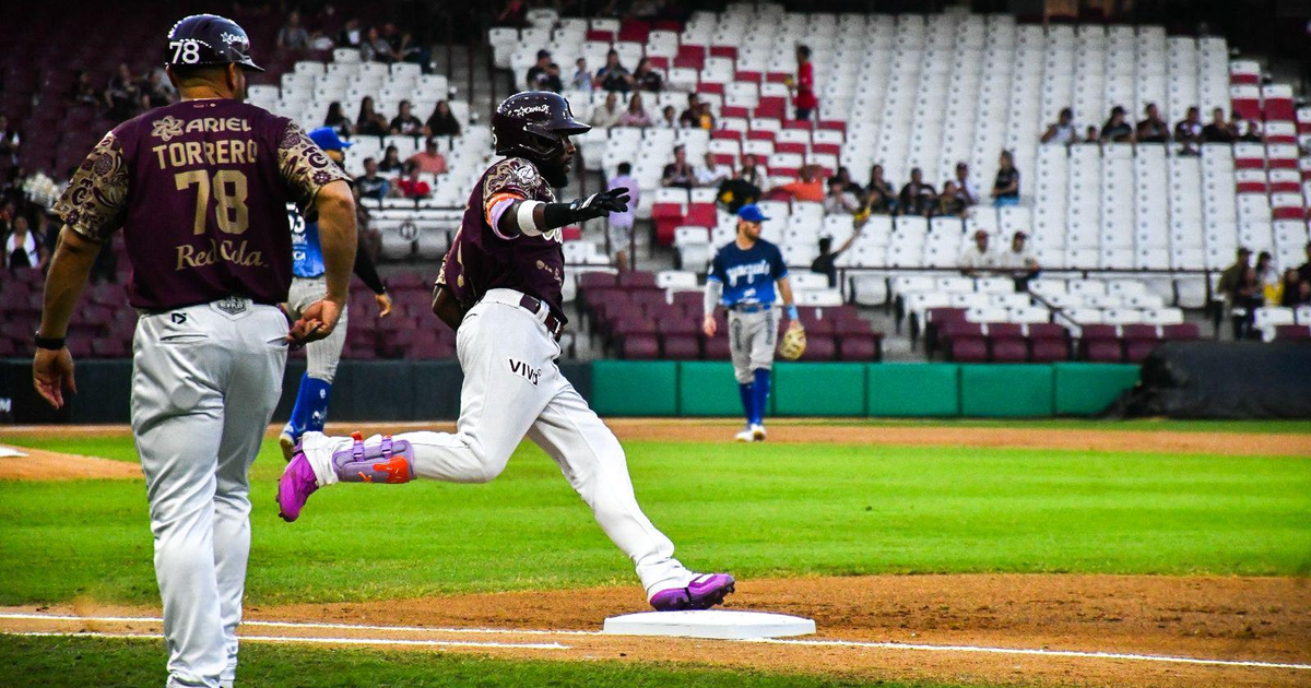 Jugador de béisbol celebrando mientras corre hacia la base durante el partido entre Tomateros y Yaquis en Culiacán.