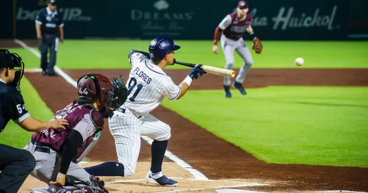 Jugador de béisbol bateando durante un juego nocturno en Culiacán