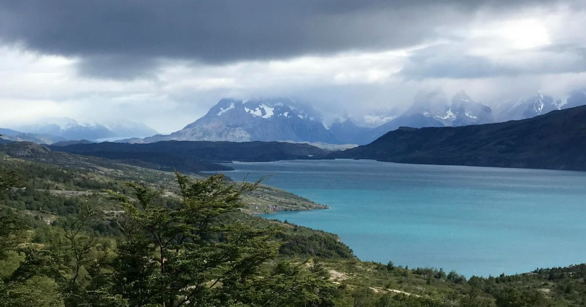 Lago turquesa rodeado de montañas nevadas en el Parque Nacional Torres del Paine, Chile.