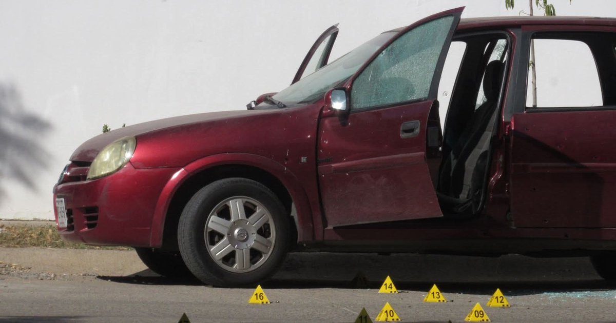 Automóvil Chevy rojo con impactos de bala y puerta abierta en escena del crimen en Mazatlán