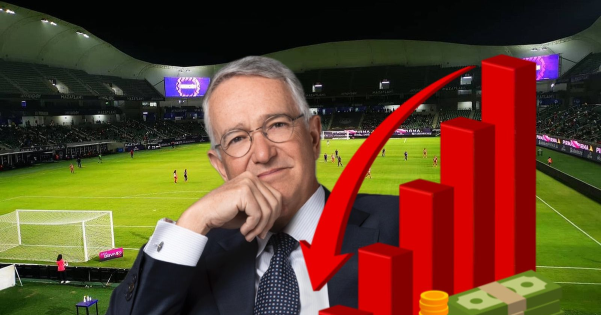 Persona analizando datos financieros en un campo de fútbol durante un partido, con un estadio lleno de espectadores.