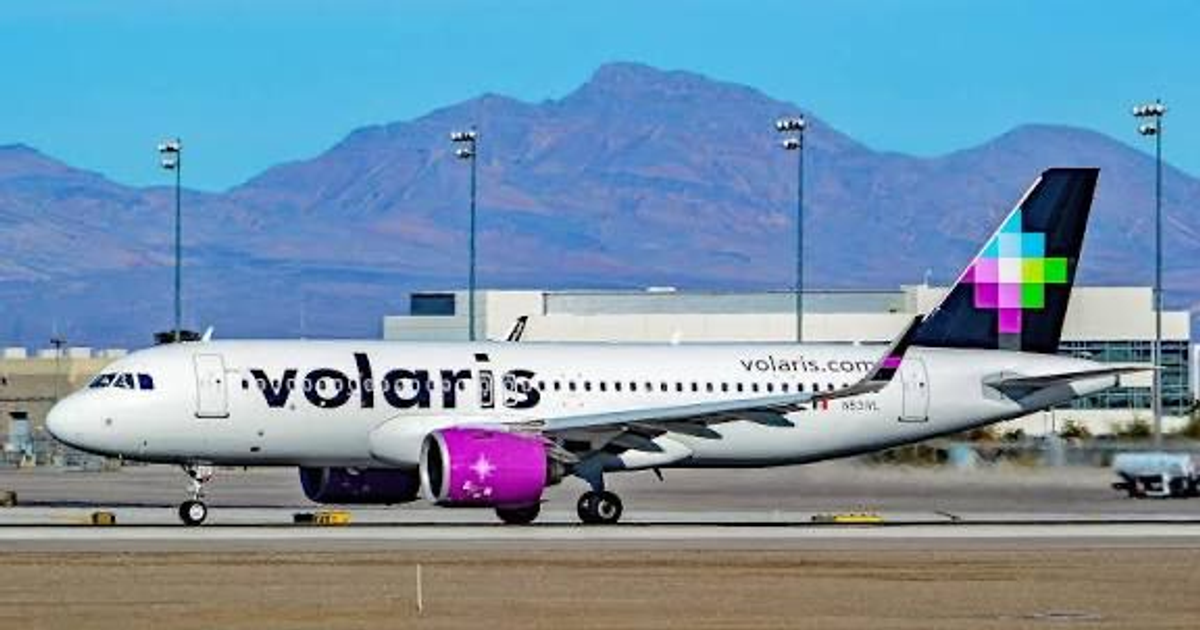 Avión de Volaris en aeropuerto con montañas y edificio, anunciando nueva ruta Mazatlán-Guadalajara.