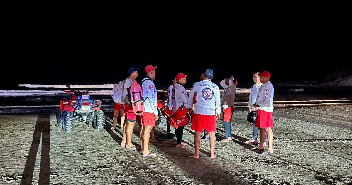Salvavidas en la playa de Mazatlán durante la noche, preparados para un rescate tras el encallamiento de un yate.