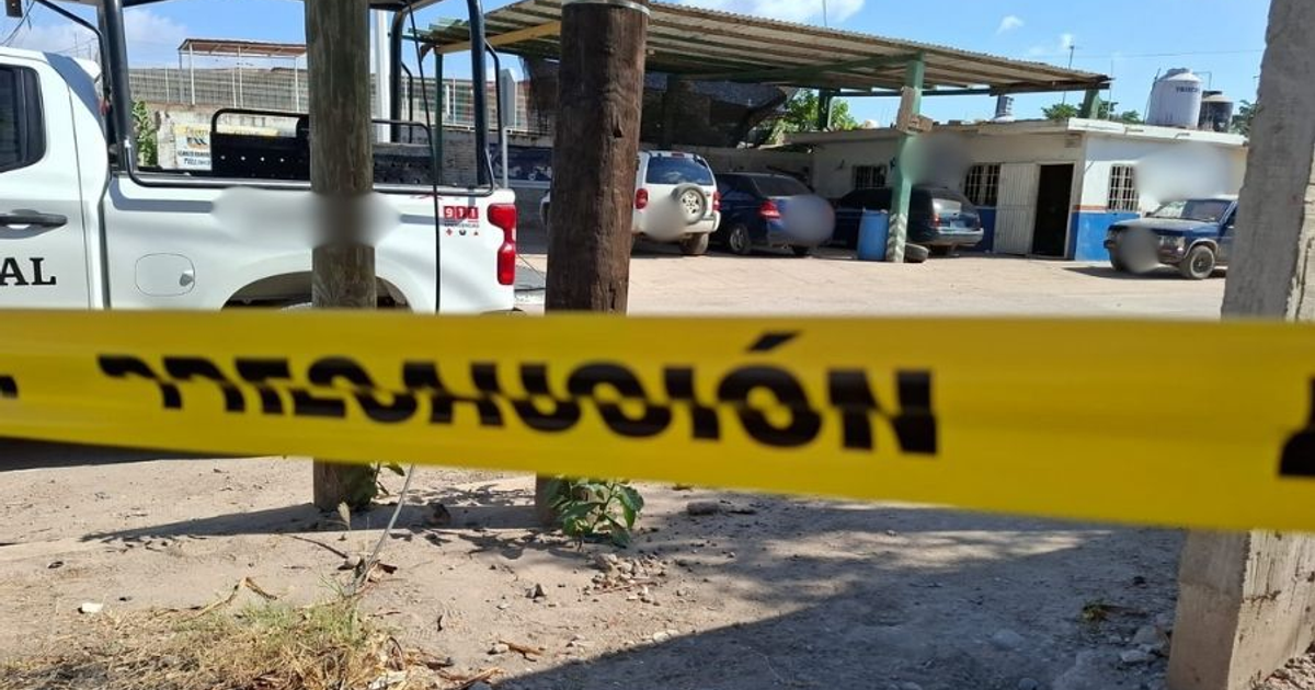 Vehículo policial y cinta de precaución en taller eléctrico tras ataque en Navolato