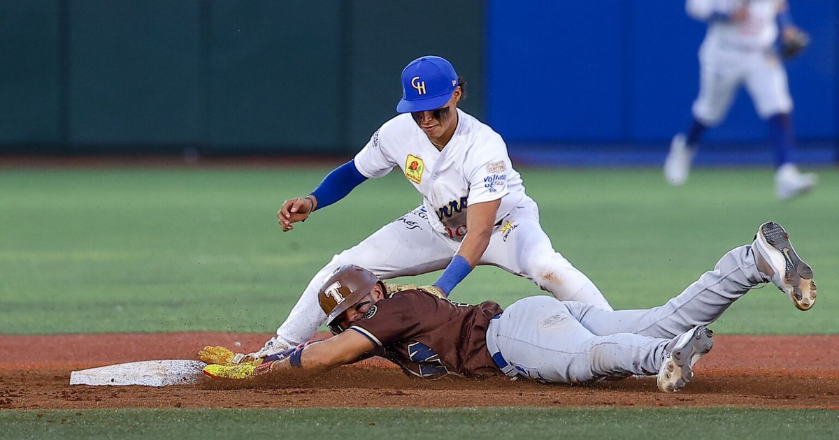 Jugador de béisbol deslizándose hacia la base durante el partido Charros de Jalisco vs Tucson Baseball Team