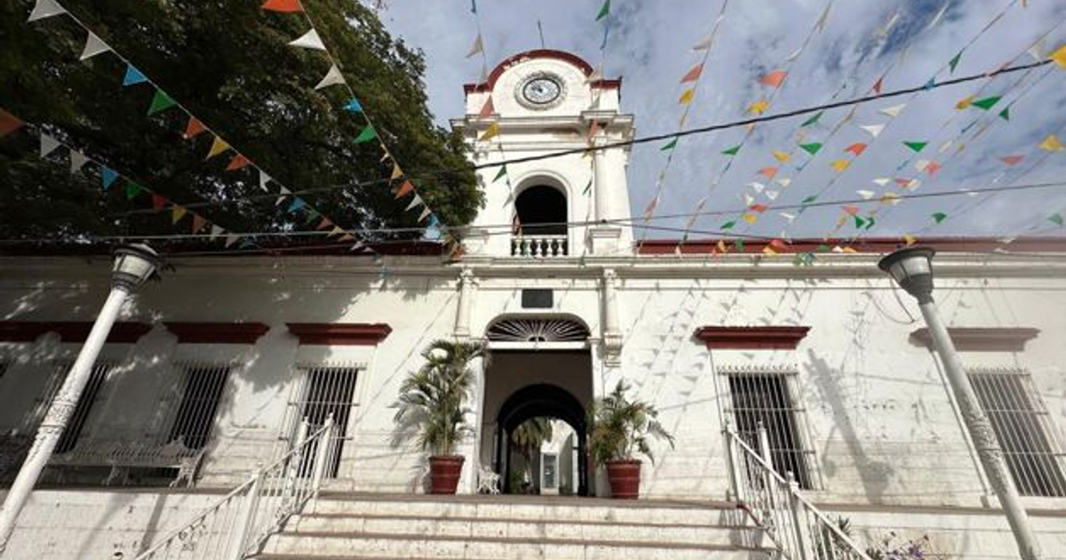 Edificio blanco con detalles rojos y torre con reloj en la Villa de Ahome, Sinaloa, durante una protesta.