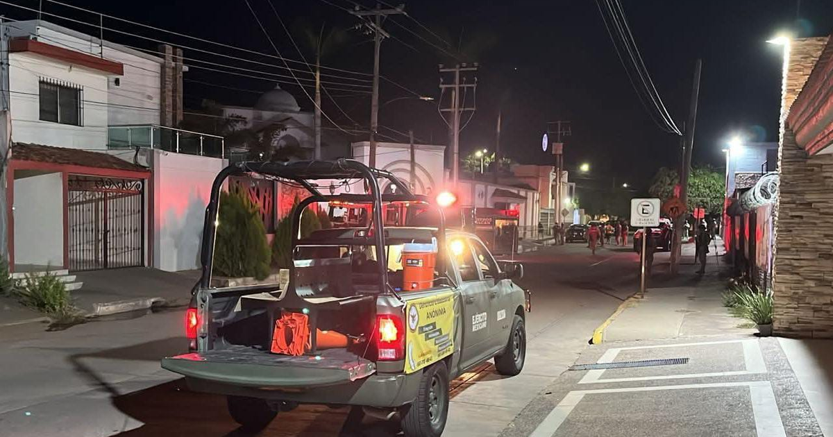 Calle nocturna en Culiacán con vehículo de seguridad en acción