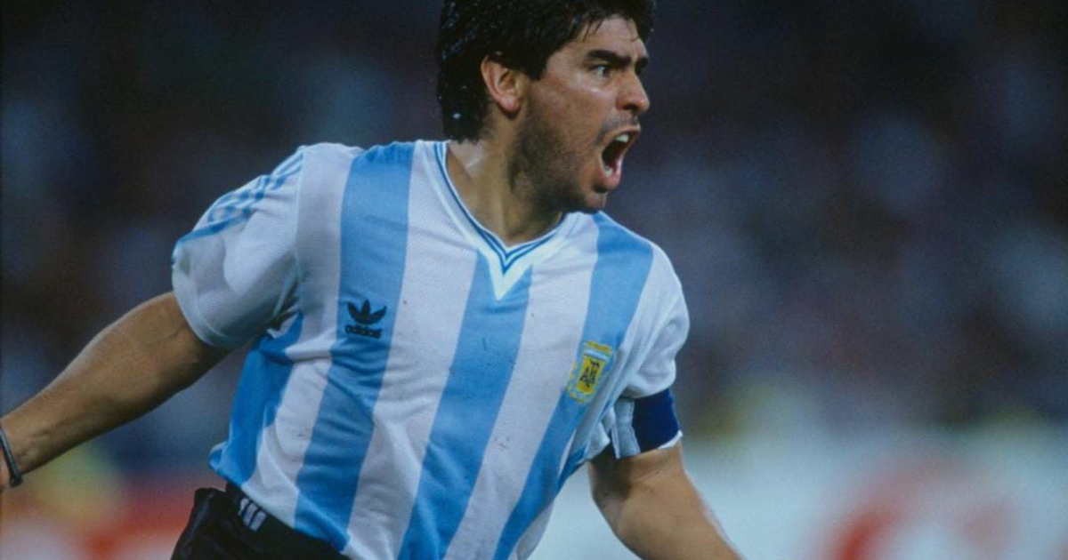 Hincha argentino celebra con camiseta de fútbol frente a la celebración de un gol.