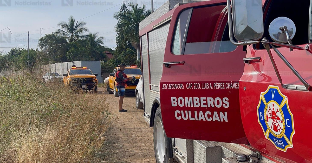 Camión de bomberos de Culiacán en un entorno rural, participando en la búsqueda de un menor en el canal Humaya.