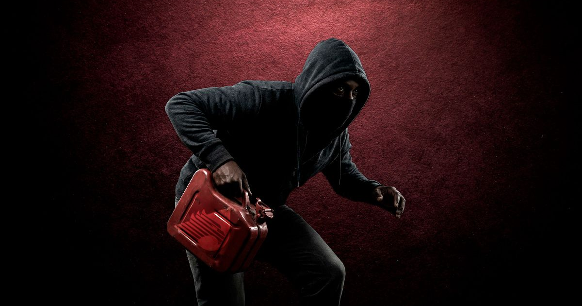 Persona encapuchada con recipiente rojo en escenario rojo alusivo al mercado ilegal de combustibles en México.