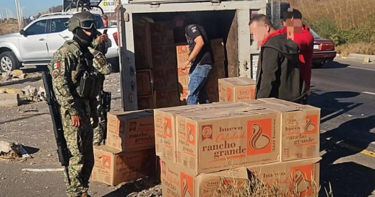 Soldado y civiles junto a vehículo volcado con mercancía 'Rancho Grande' en Culiacán