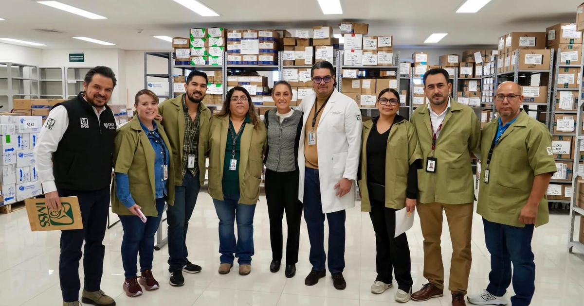 Empleados del IMSS posando en un almacén con cajas detrás, Ciudad Juárez