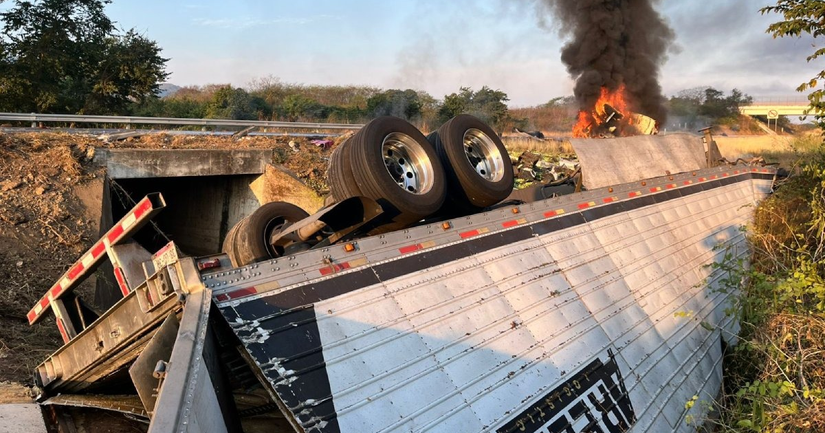 Tráiler volcado y en llamas en autopista Mazatlán–El Rosario, con humo negro en el aire y un puente al fondo